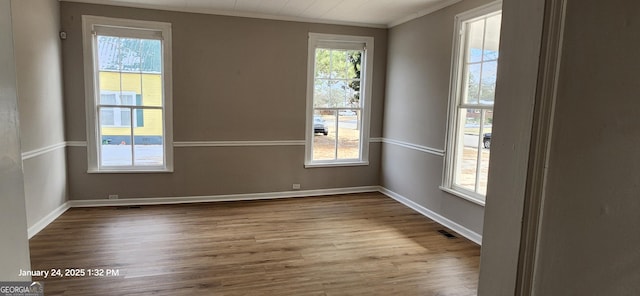 unfurnished room featuring hardwood / wood-style flooring and ornamental molding