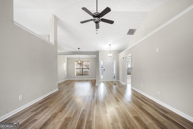 unfurnished living room with lofted ceiling, hardwood / wood-style floors, and ceiling fan