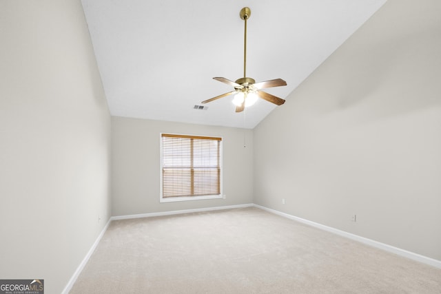 empty room featuring light carpet, baseboards, visible vents, and vaulted ceiling