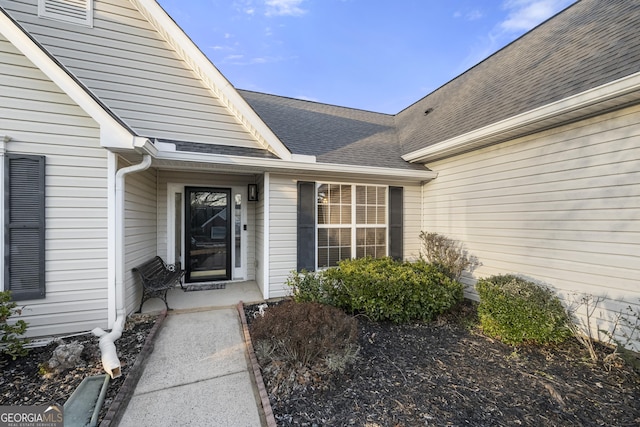 entrance to property with roof with shingles