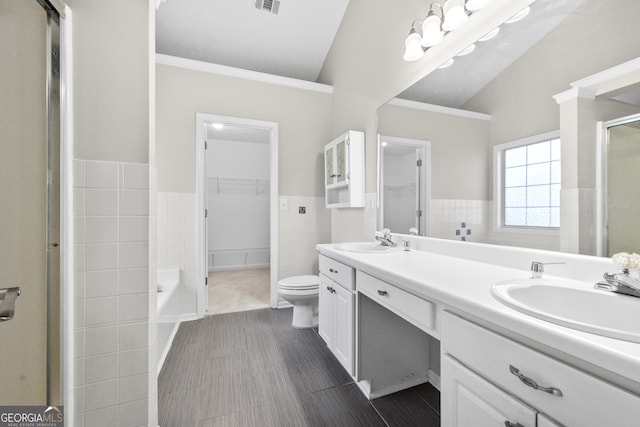 bathroom with vaulted ceiling, a sink, and tile walls