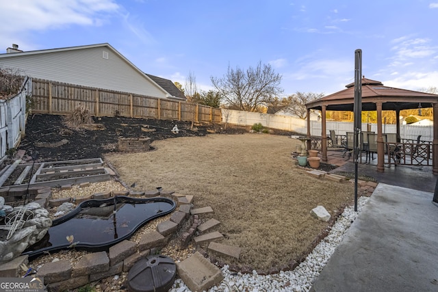 view of yard featuring a patio area, a fenced backyard, and a gazebo