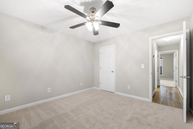 unfurnished bedroom with light colored carpet and ceiling fan