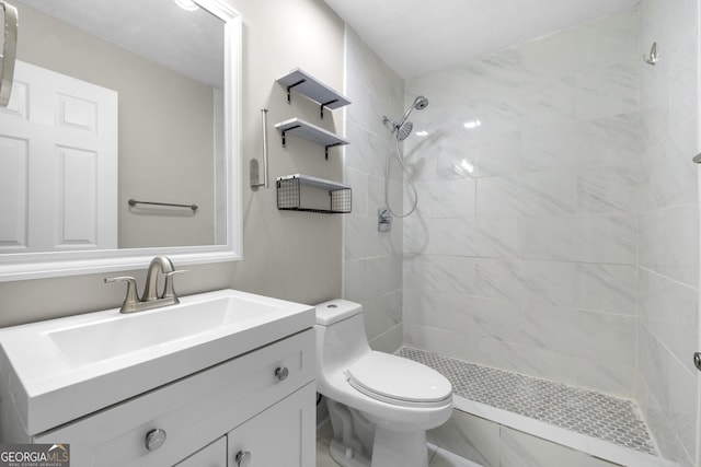 bathroom featuring vanity, toilet, and a tile shower