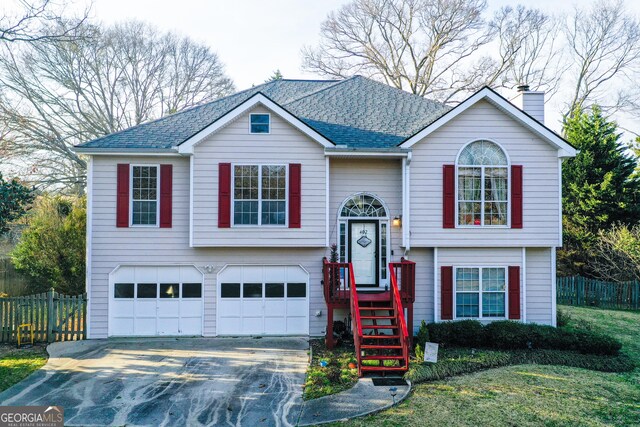 split foyer home featuring a garage and a front lawn