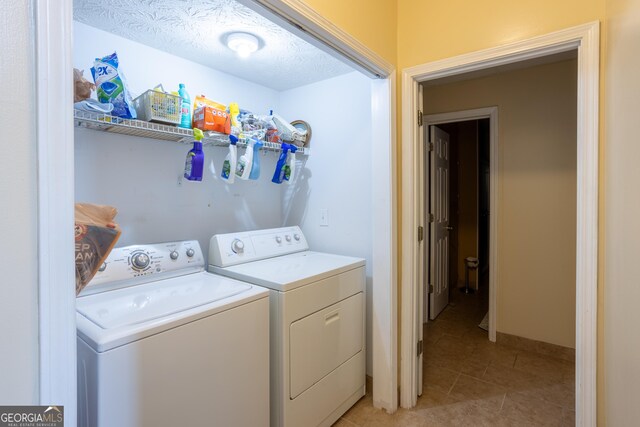 washroom featuring laundry area, a textured ceiling, washer and dryer, and light tile patterned floors