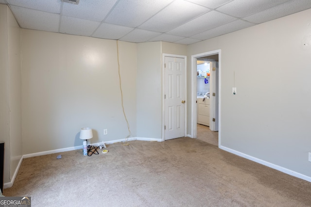 carpeted spare room with baseboards and a drop ceiling