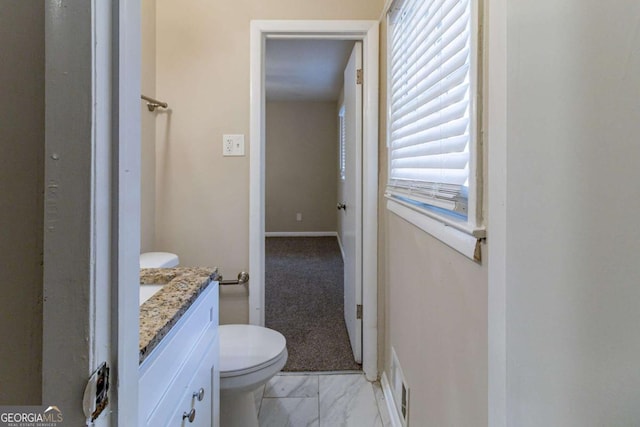 bathroom featuring vanity, toilet, and a wealth of natural light