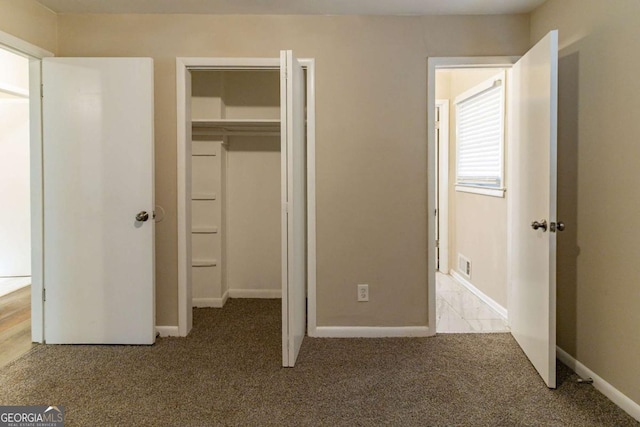 unfurnished bedroom featuring light colored carpet and a closet