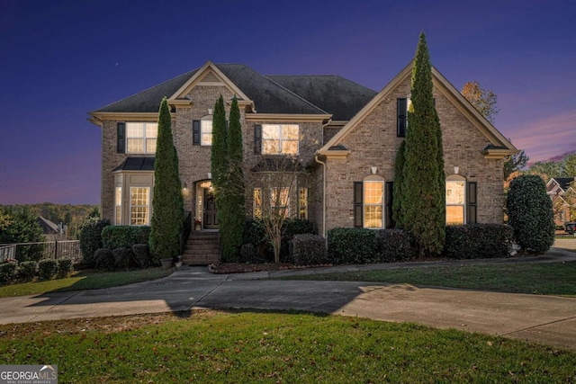 view of front of house featuring fence and brick siding