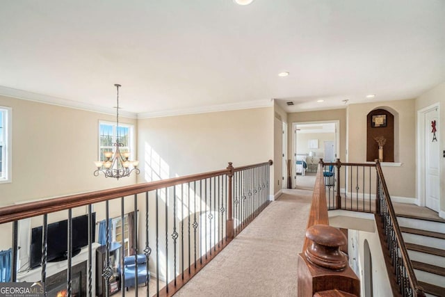 corridor featuring baseboards, ornamental molding, an inviting chandelier, carpet floors, and recessed lighting