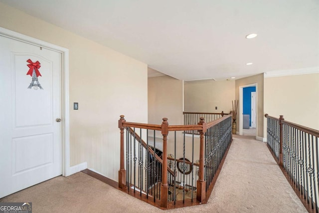 hall featuring carpet floors, recessed lighting, baseboards, and an upstairs landing