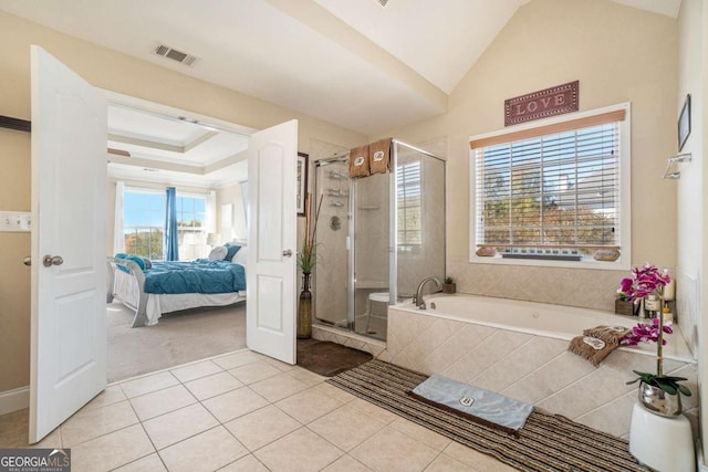 ensuite bathroom with lofted ceiling, a garden tub, visible vents, tile patterned floors, and a stall shower