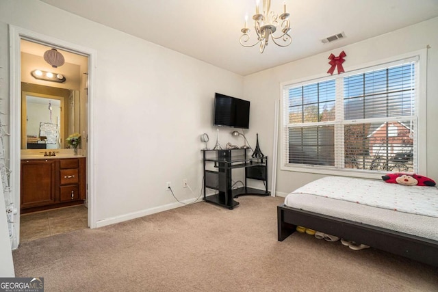 bedroom with baseboards, visible vents, light colored carpet, ensuite bath, and a notable chandelier