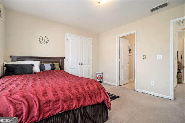 carpeted bedroom with a closet, visible vents, and baseboards