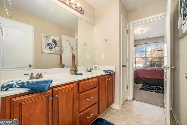 ensuite bathroom featuring double vanity, tile patterned flooring, a sink, and ensuite bathroom