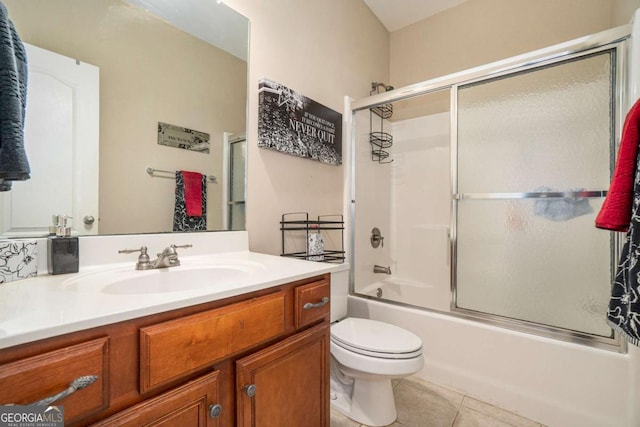 bathroom featuring tile patterned flooring, vanity, toilet, and bath / shower combo with glass door