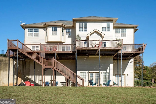 back of property featuring stairway, a lawn, and a wooden deck