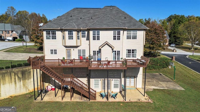 rear view of house with a yard, stairs, and a wooden deck