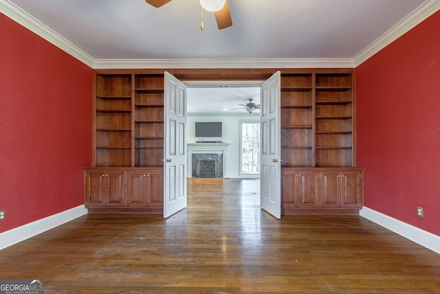 unfurnished living room featuring ornamental molding, dark hardwood / wood-style floors, and built in shelves