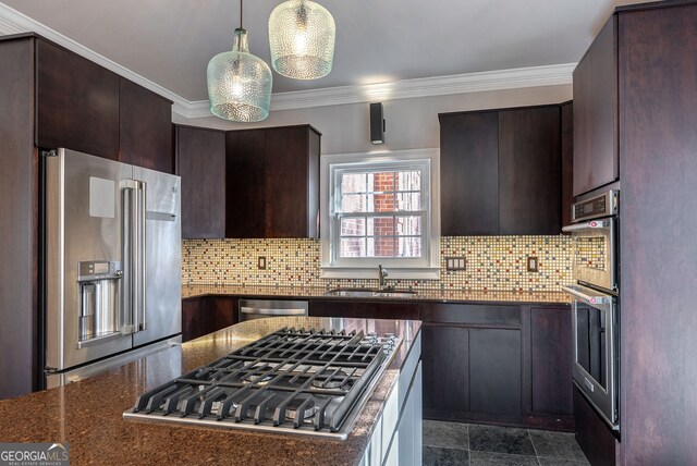 kitchen featuring dark brown cabinets, appliances with stainless steel finishes, decorative light fixtures, and a kitchen island