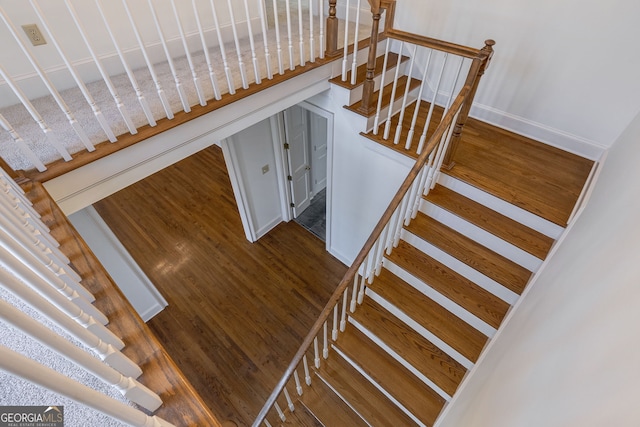 stairs featuring hardwood / wood-style floors