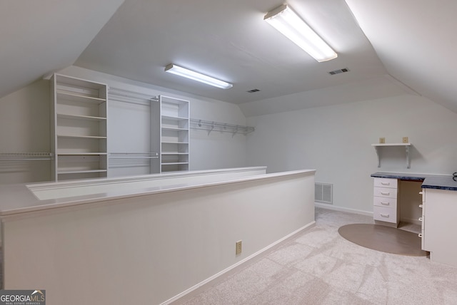 interior space with lofted ceiling and light carpet