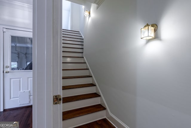 staircase featuring crown molding and hardwood / wood-style flooring