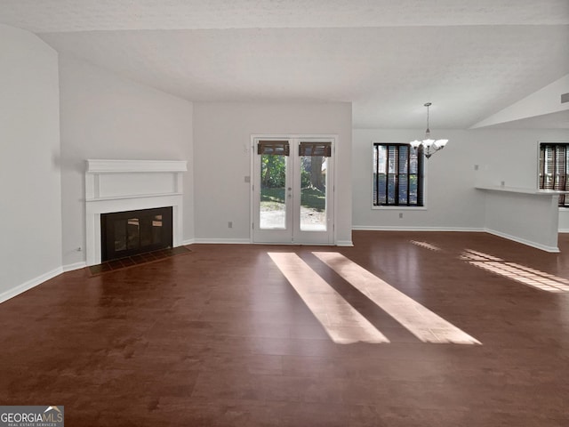2268 Turtle Club Dr NE, Marietta, GA 30066 - unfurnished living room featuring vaulted ceiling, a chandelier, a fireplace with flush hearth, wood finished floors, and french doors