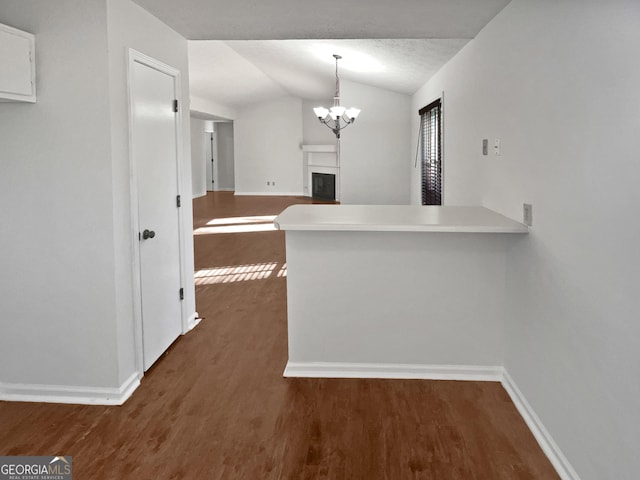 2268 Turtle Club Dr NE, Marietta, GA 30066 - kitchen featuring lofted ceiling, dark wood finished floors, a peninsula, white cabinets, and a chandelier