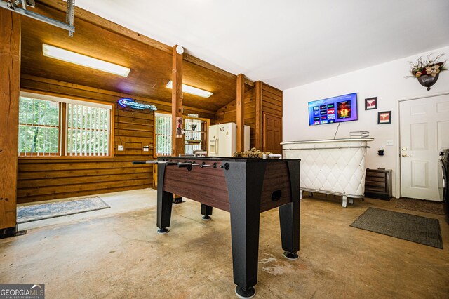 rec room with concrete floors and wood walls