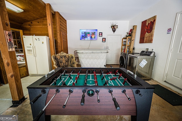 game room with concrete floors and independent washer and dryer