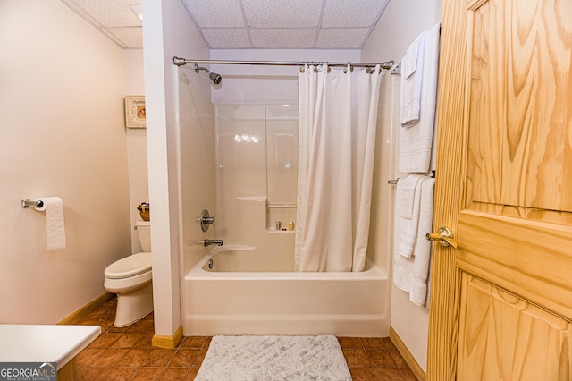 bathroom featuring a paneled ceiling, shower / tub combo with curtain, tile patterned floors, and toilet