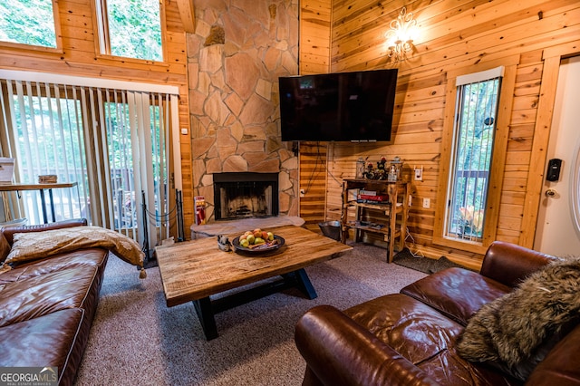 living room with a stone fireplace, carpet floors, a high ceiling, and wood walls