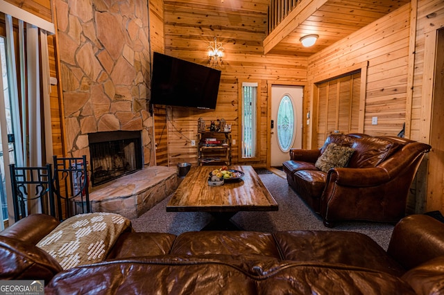 carpeted living room featuring wood ceiling, a fireplace, and wooden walls