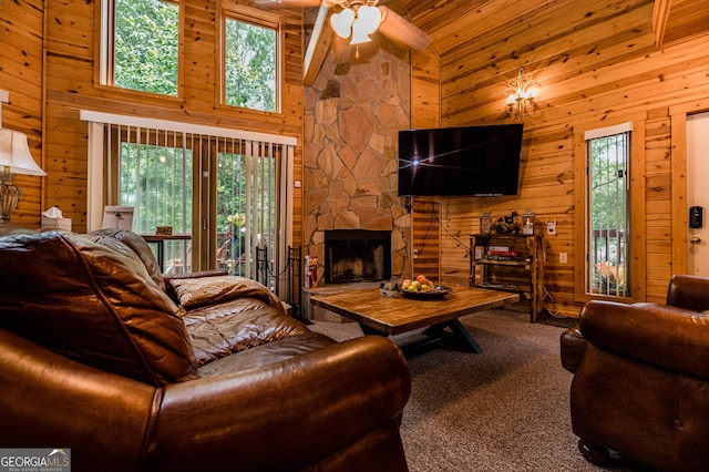 carpeted living room with wood ceiling, ceiling fan, high vaulted ceiling, a fireplace, and wood walls