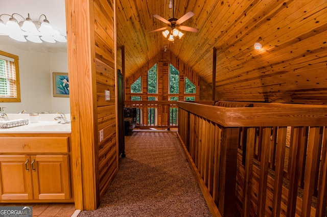 hall with lofted ceiling, sink, carpet, and wooden ceiling