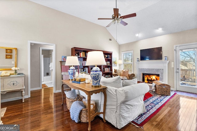 living room with dark hardwood / wood-style flooring, a fireplace, vaulted ceiling, and ceiling fan