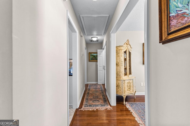 hallway featuring dark hardwood / wood-style floors and a textured ceiling