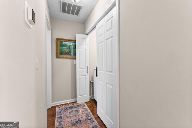 hall featuring dark hardwood / wood-style flooring and a textured ceiling