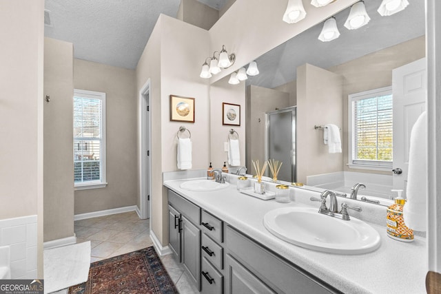 bathroom featuring tile patterned flooring, shower with separate bathtub, vanity, and a textured ceiling