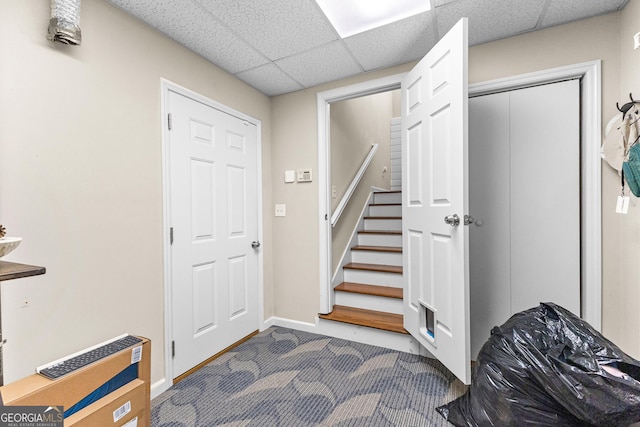 carpeted foyer featuring a drop ceiling