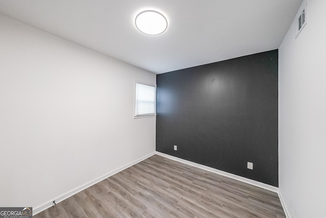 unfurnished room with wood-type flooring