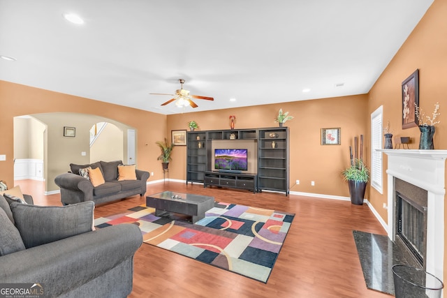 living room featuring light hardwood / wood-style flooring, a fireplace, and ceiling fan