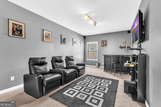 carpeted cinema room with bar area and rail lighting