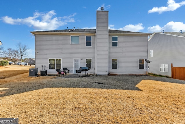 back of house featuring cooling unit, a lawn, and a patio area