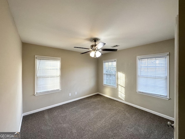 unfurnished room featuring ceiling fan and dark carpet