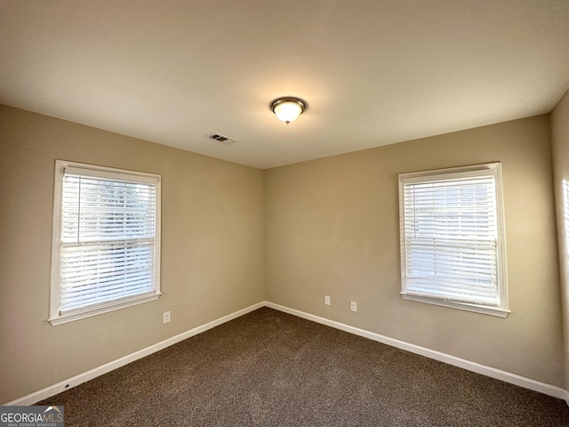 carpeted spare room featuring plenty of natural light