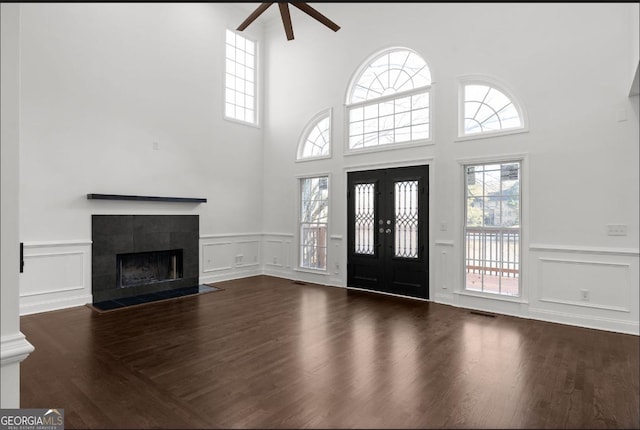 foyer featuring a tiled fireplace, dark hardwood / wood-style floors, and ceiling fan