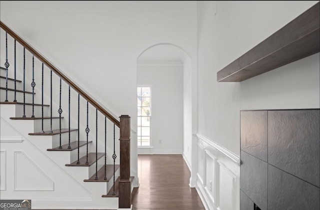 staircase with ornamental molding and wood-type flooring